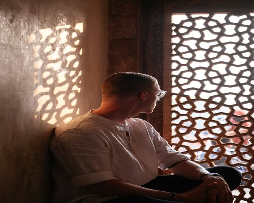 A person looking thoughtfully out of a window in India during an afternoon break